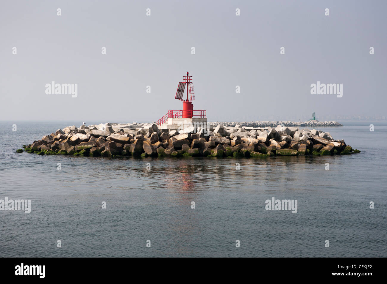 Accropodes for the shore protection of Chioggia , Venezia, on the left side of the bay entrance, as shown by the red tower. Stock Photo