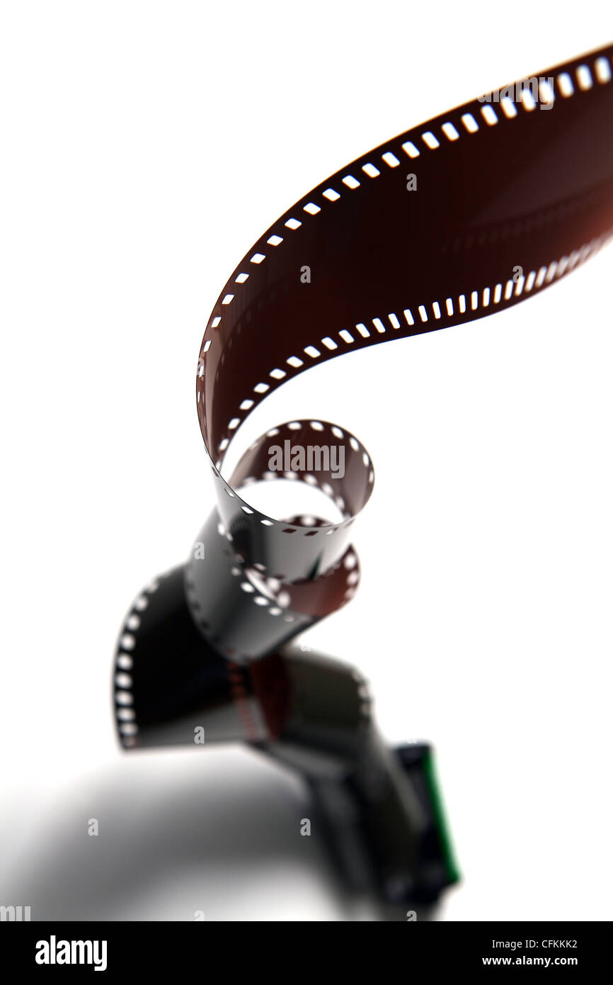 A reel of film rolling downwards, twisting the film along the way Stock