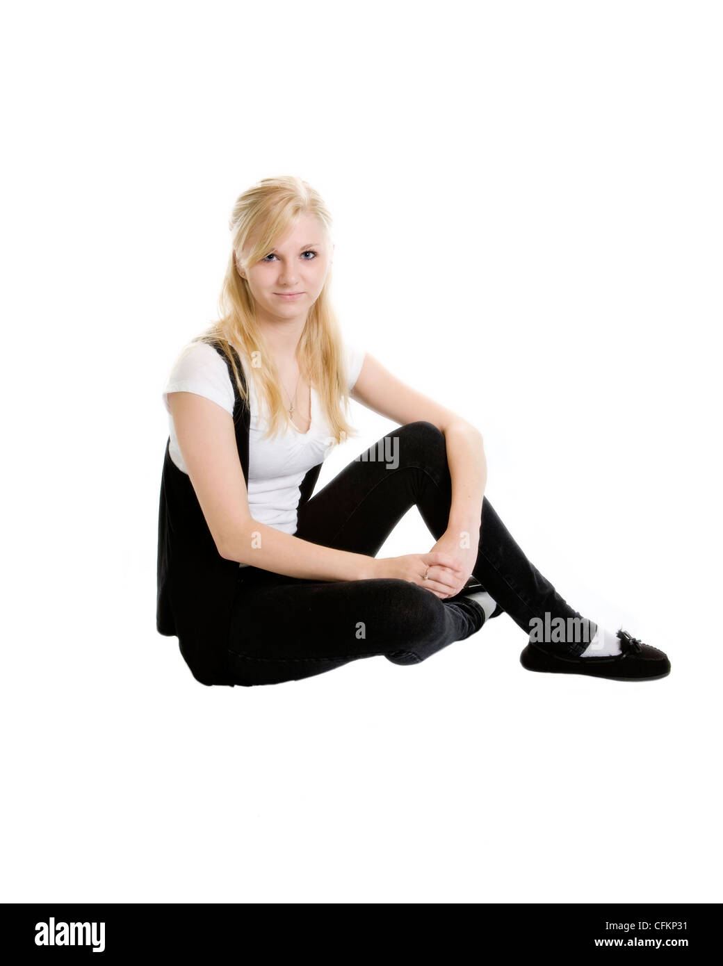 A teen girl sits in a casual manner. Stock Photo
