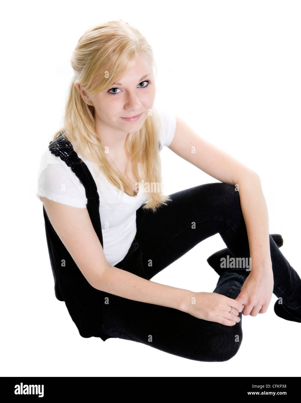 A teen girl sits in a casual manner. Stock Photo