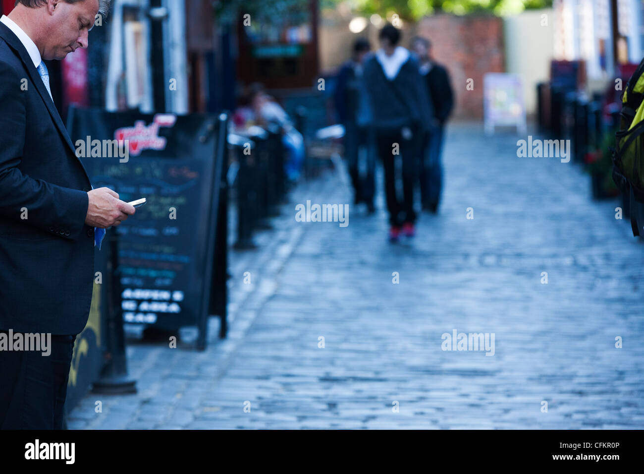 A male adult use a cellular telephone outside a bar on Ashton Lane in Glasgow Scotland. Ashton lane is famous for bars Stock Photo