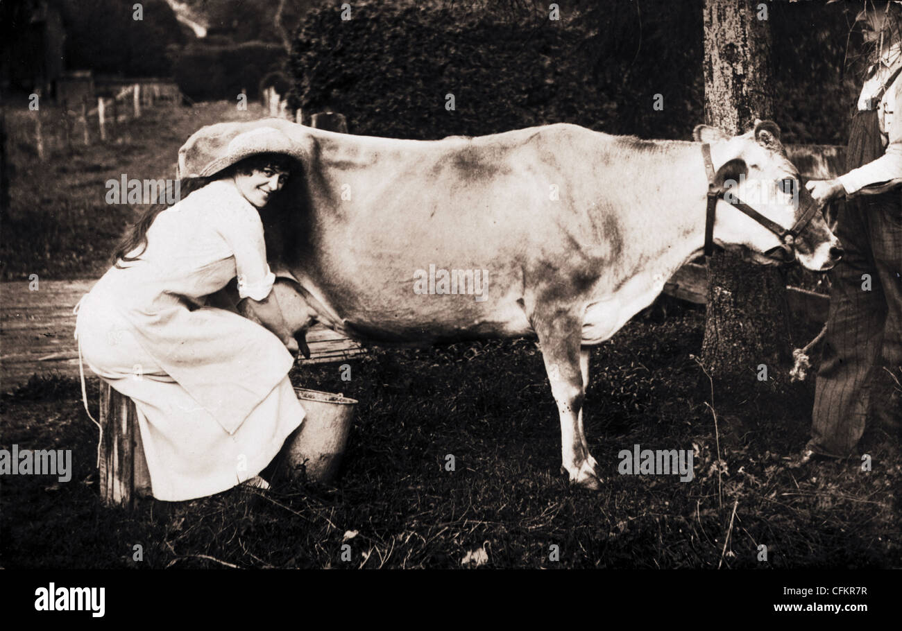 Beautiful Milkmaid Milking a Cow Stock Photo