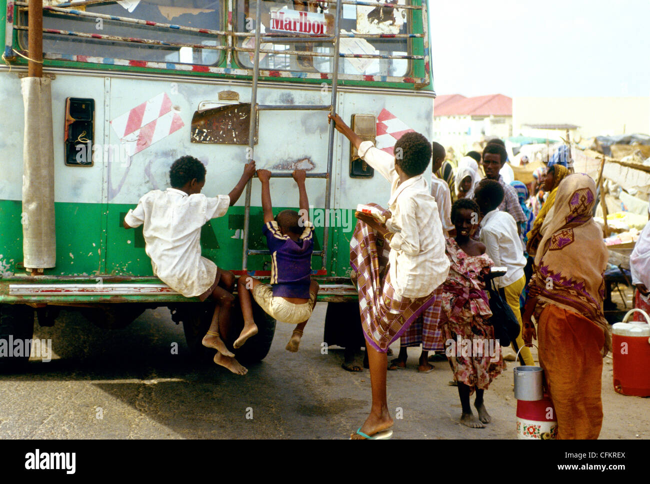Young boys hang on to a Mogadishu city bus-Somalia - East Africa Stock Photo