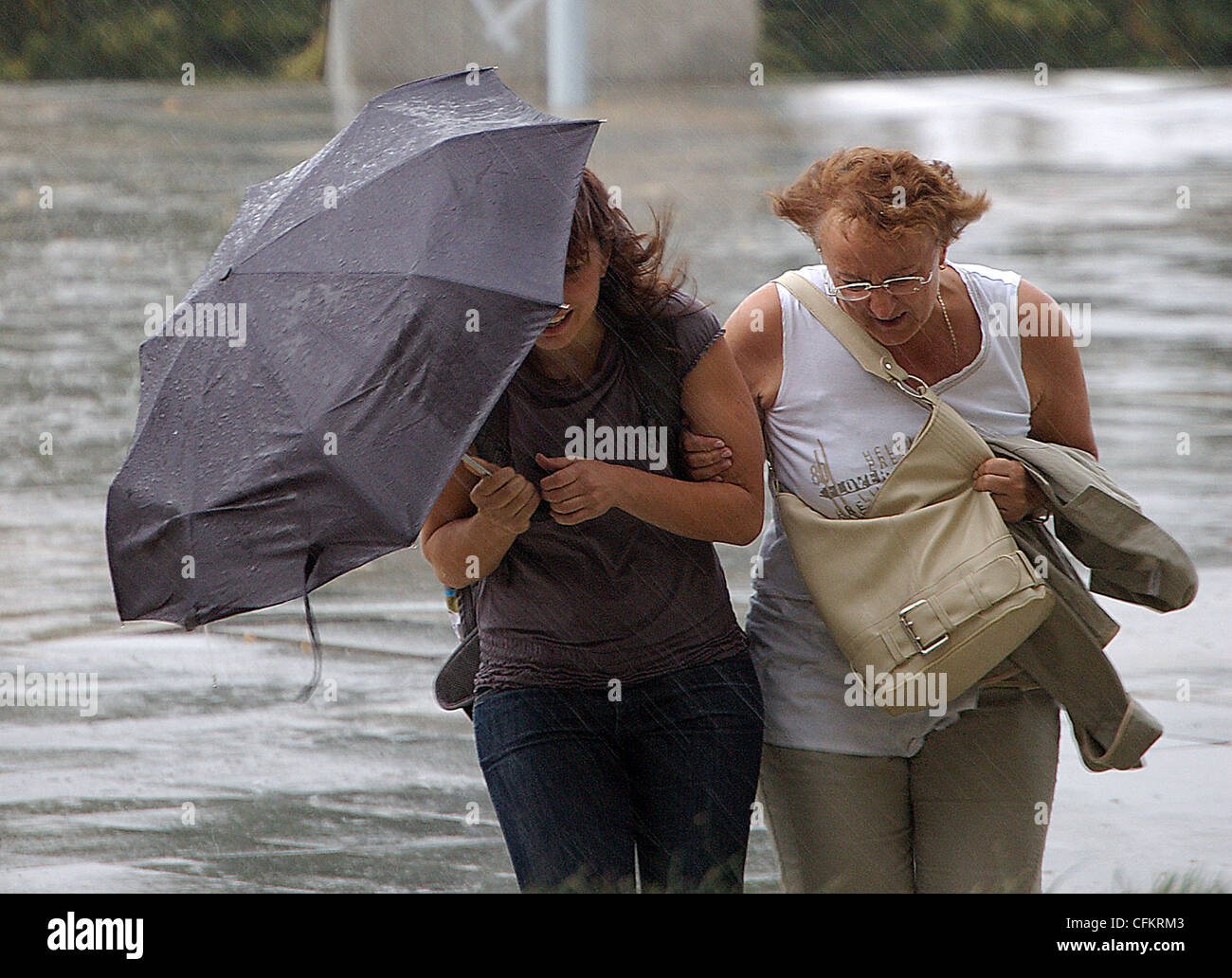 Two Women Run From A Rain Shower Holding An Umbrella Stock Photo Alamy Two Women Run From A Rain Shower Holding An Umbrella Stock Photo Alamy