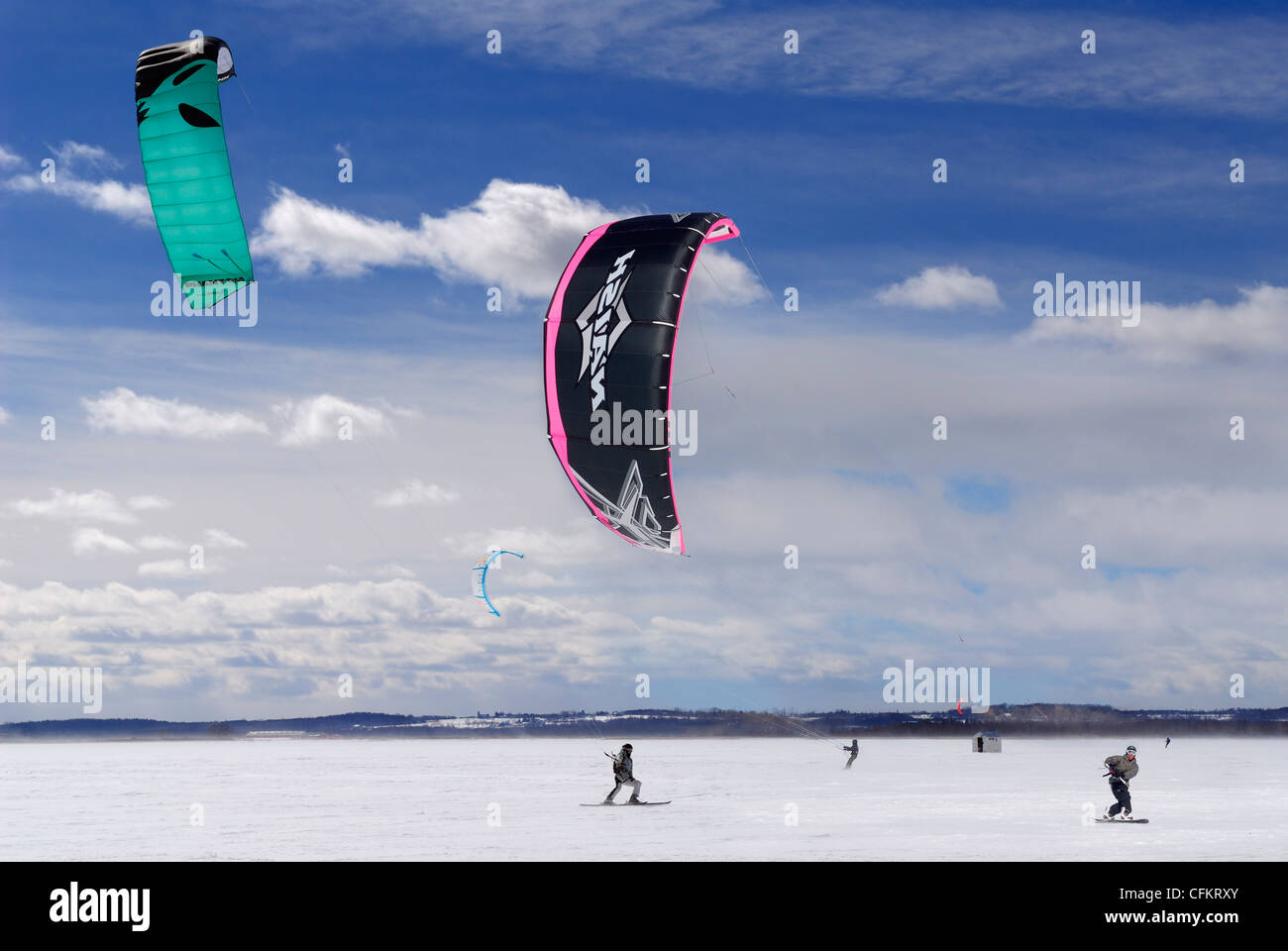 Foil kites and windrider kite boarders and skiers on frozen snow covered Lake Simcoe Ontario Stock Photo