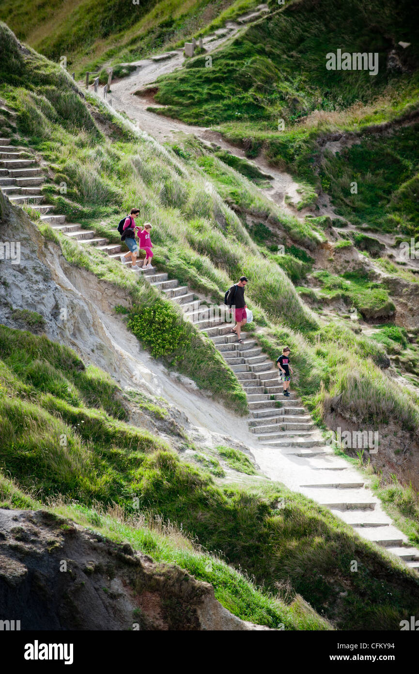 A family walk down the coast path to Durdle Door in Dorset, UK Stock