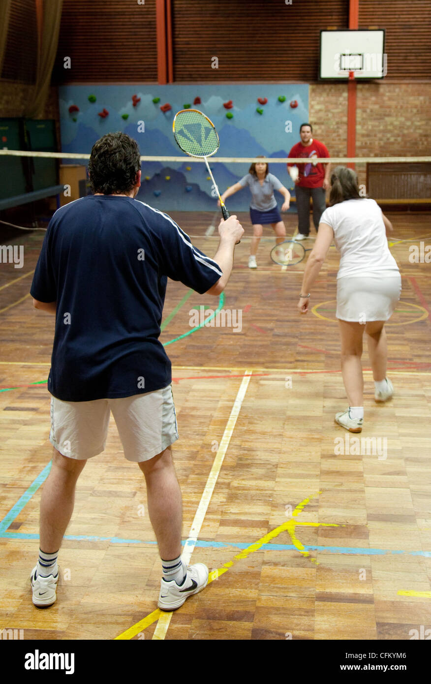 People playing a game of doubles badminton at their local club, Newmarket Suffolk UK Stock Photo