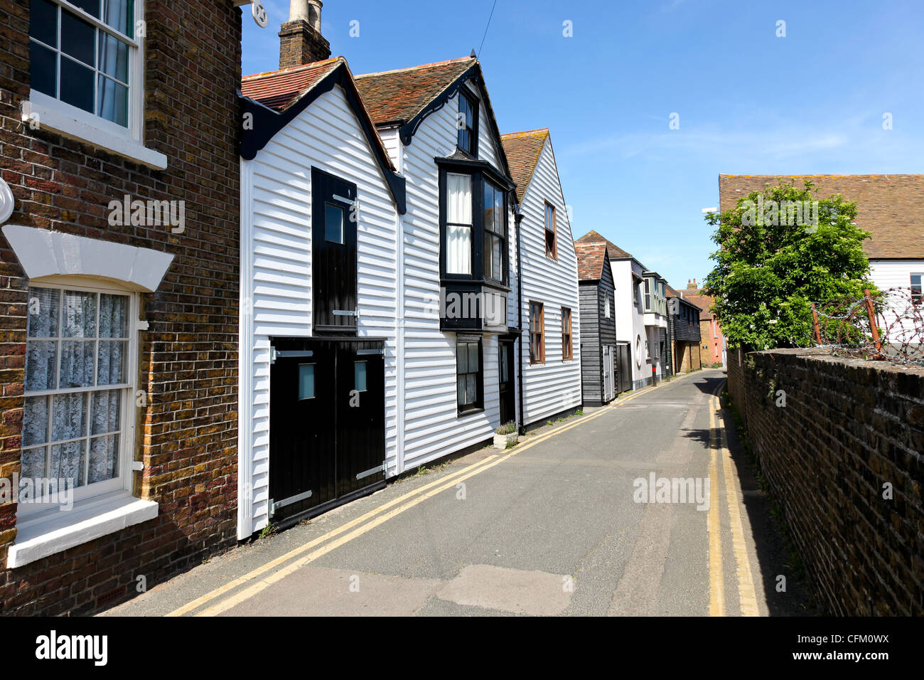Traditional white painted weatherboarded houses in a side street of the coastal town of Whitstable, Kent, UK Stock Photo
