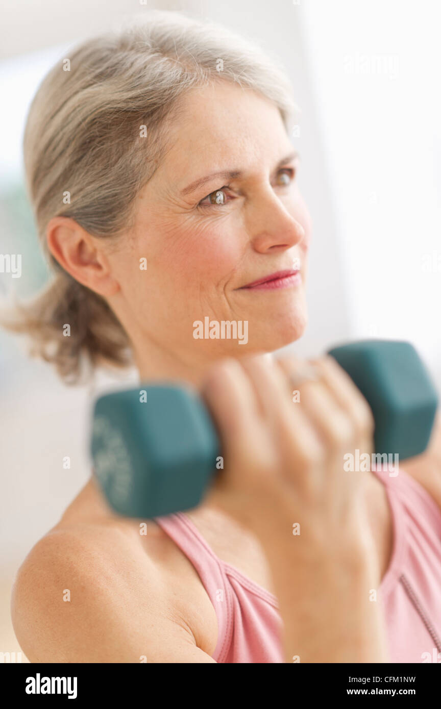 USA, New Jersey, Jersey City, Portrait of senior woman exercising with dumbbells in gym Stock Photo