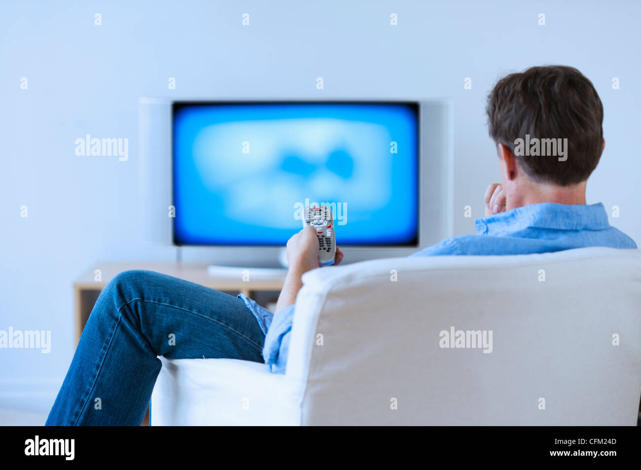 Jersey City, New Jersey, Man watching tv in living room Stock Photo