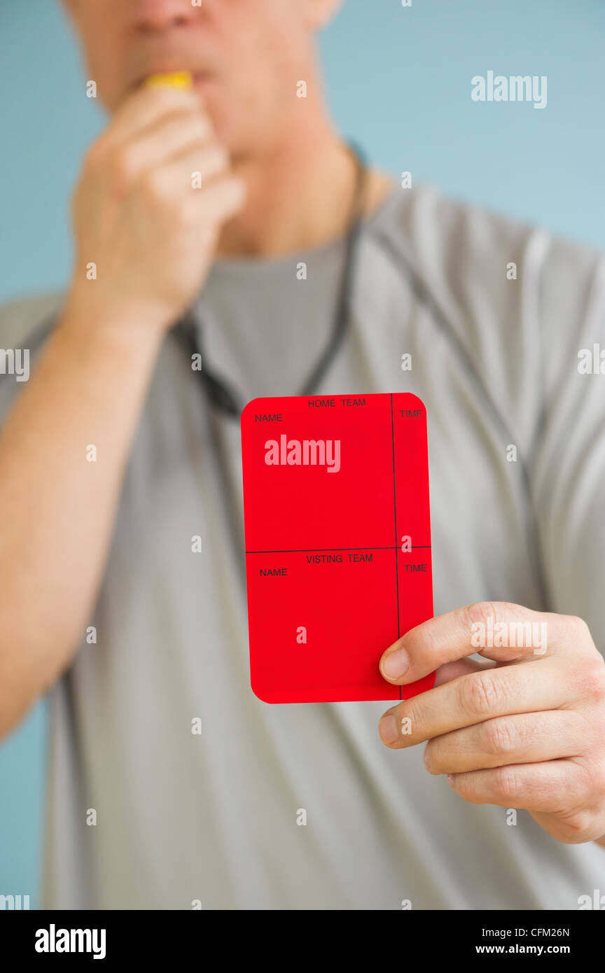 Male referee showing red card, studio shot Stock Photo