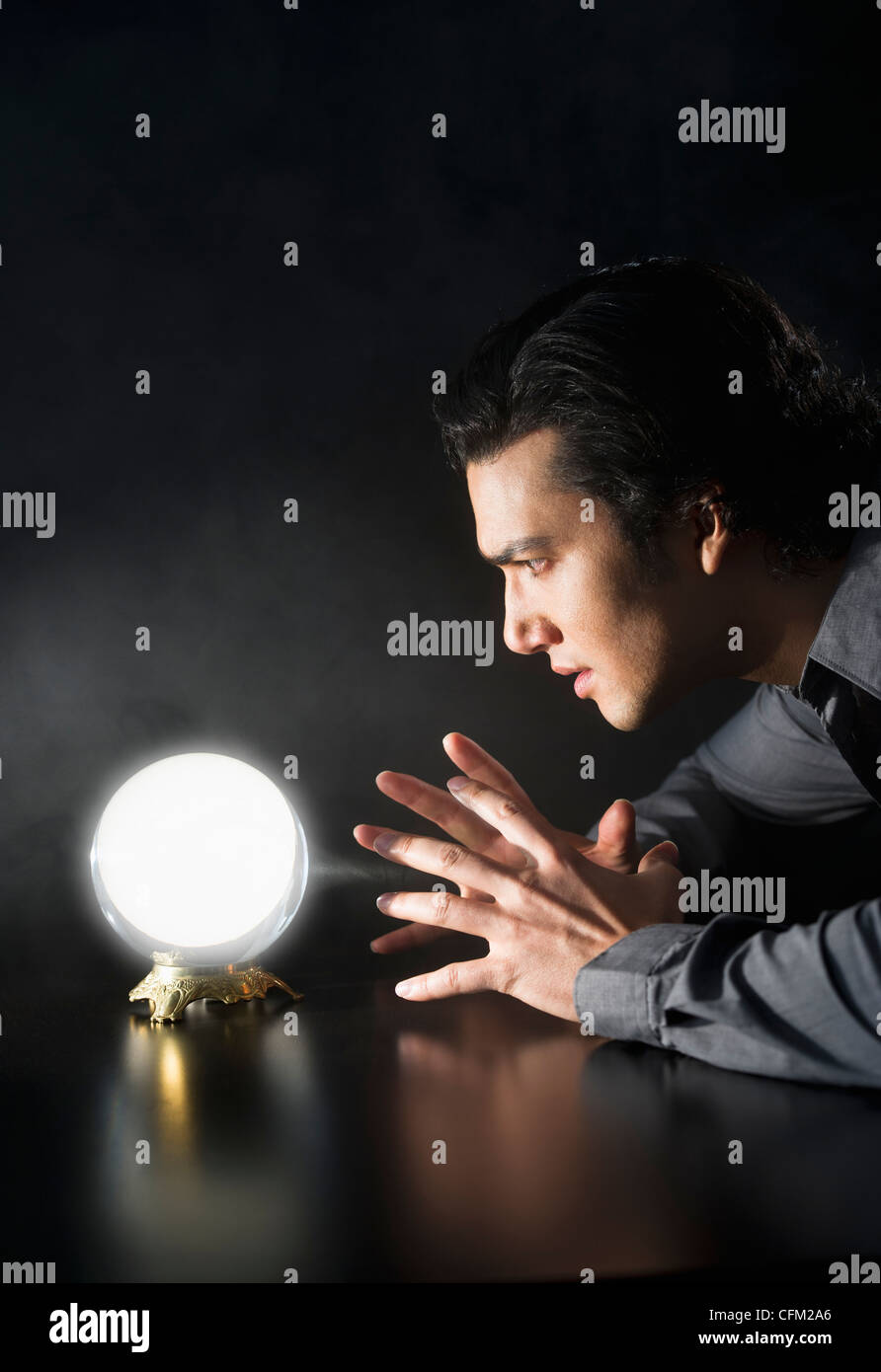 Studio shot of businessman looking at crystal ball Stock Photo - Alamy