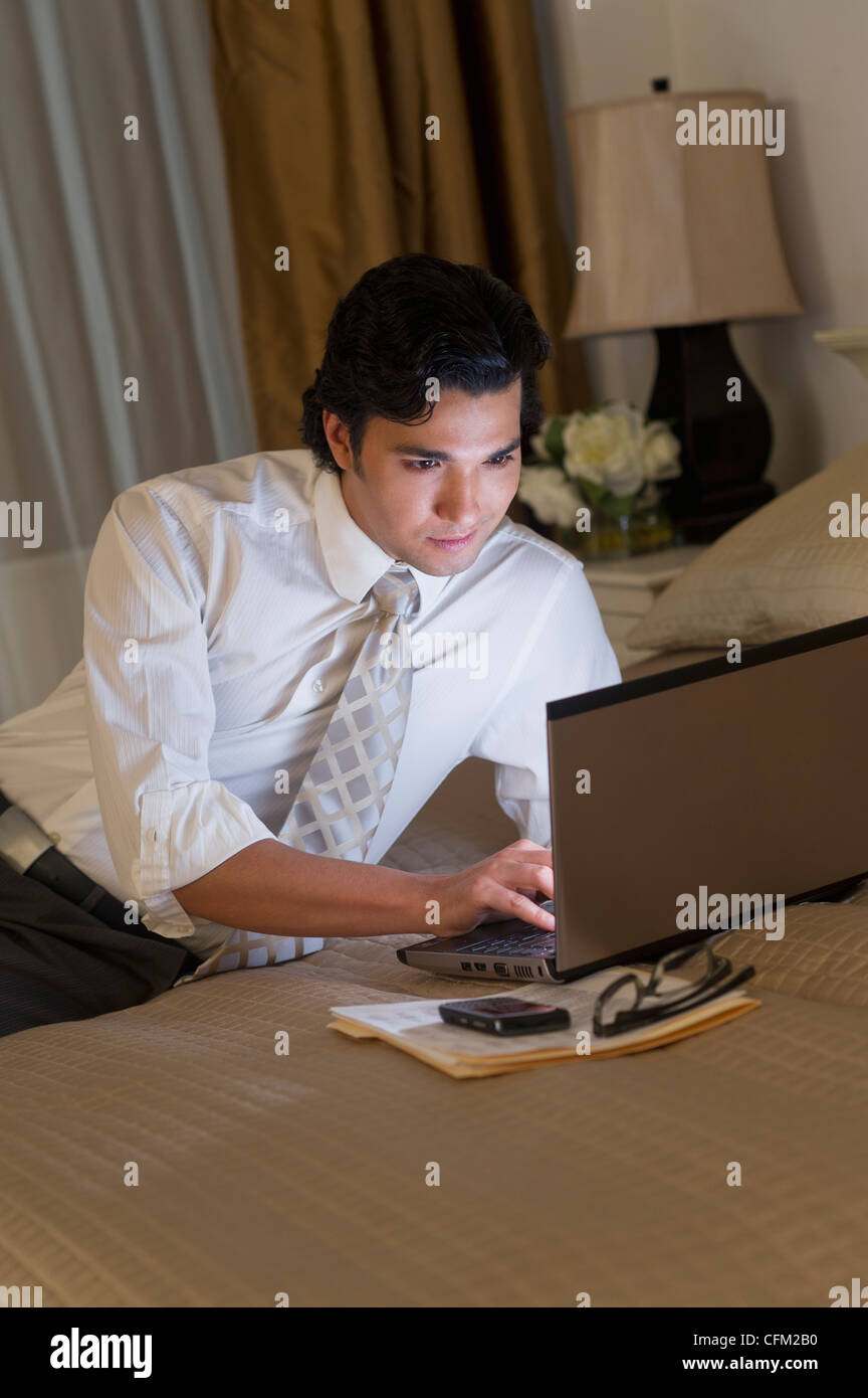 USA, New Jersey, Jersey City, Businessman working on laptop in hotel room Stock Photo
