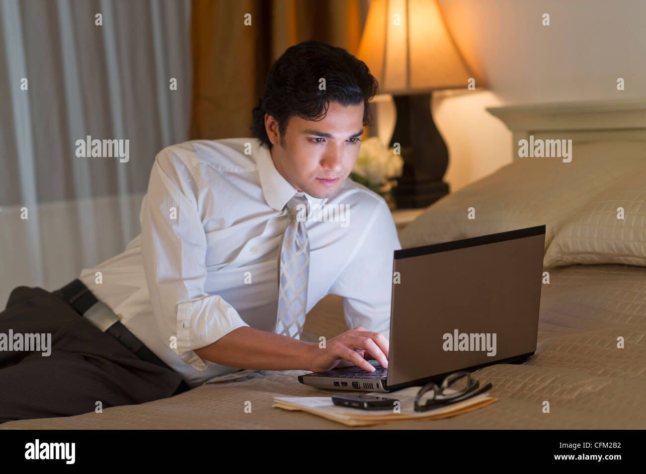 USA, New Jersey, Jersey City, Businessman working on laptop in hotel room Stock Photo