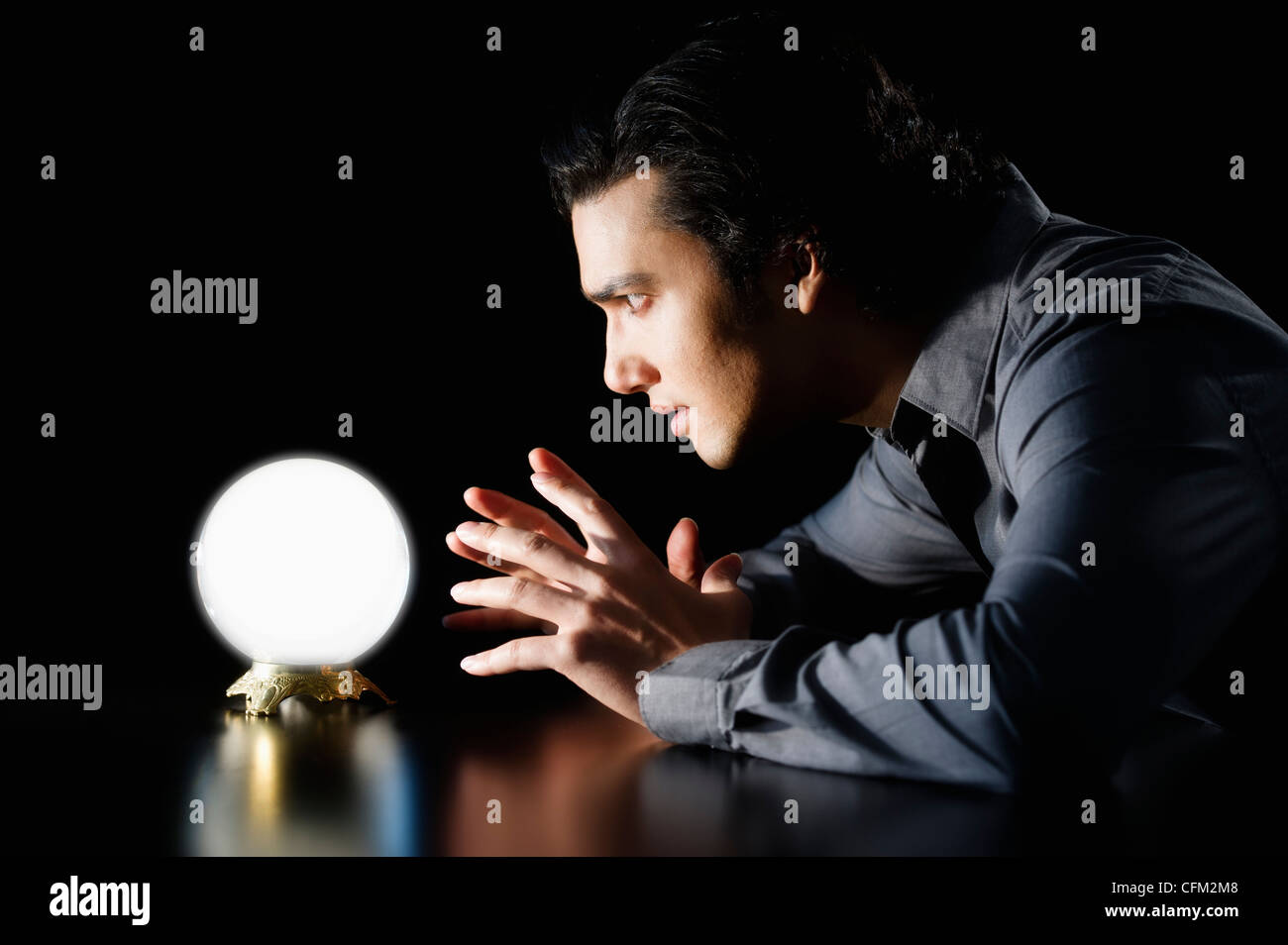 Studio shot of businessman staring at crystal ball Stock Photo - Alamy