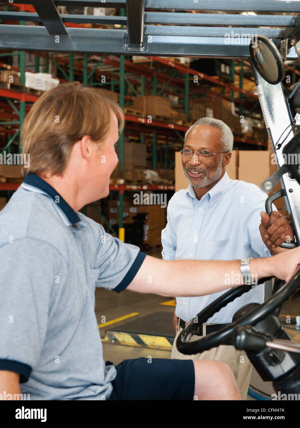 USA, California, Santa Ana, Businessman talking to forklift driver in