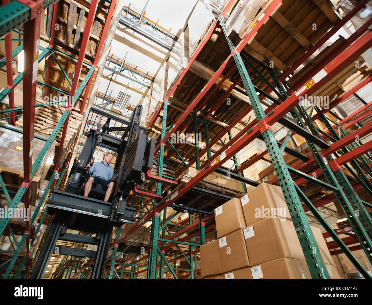 USA, California, Santa Ana, Forklift truck stacking boxes in warehouse