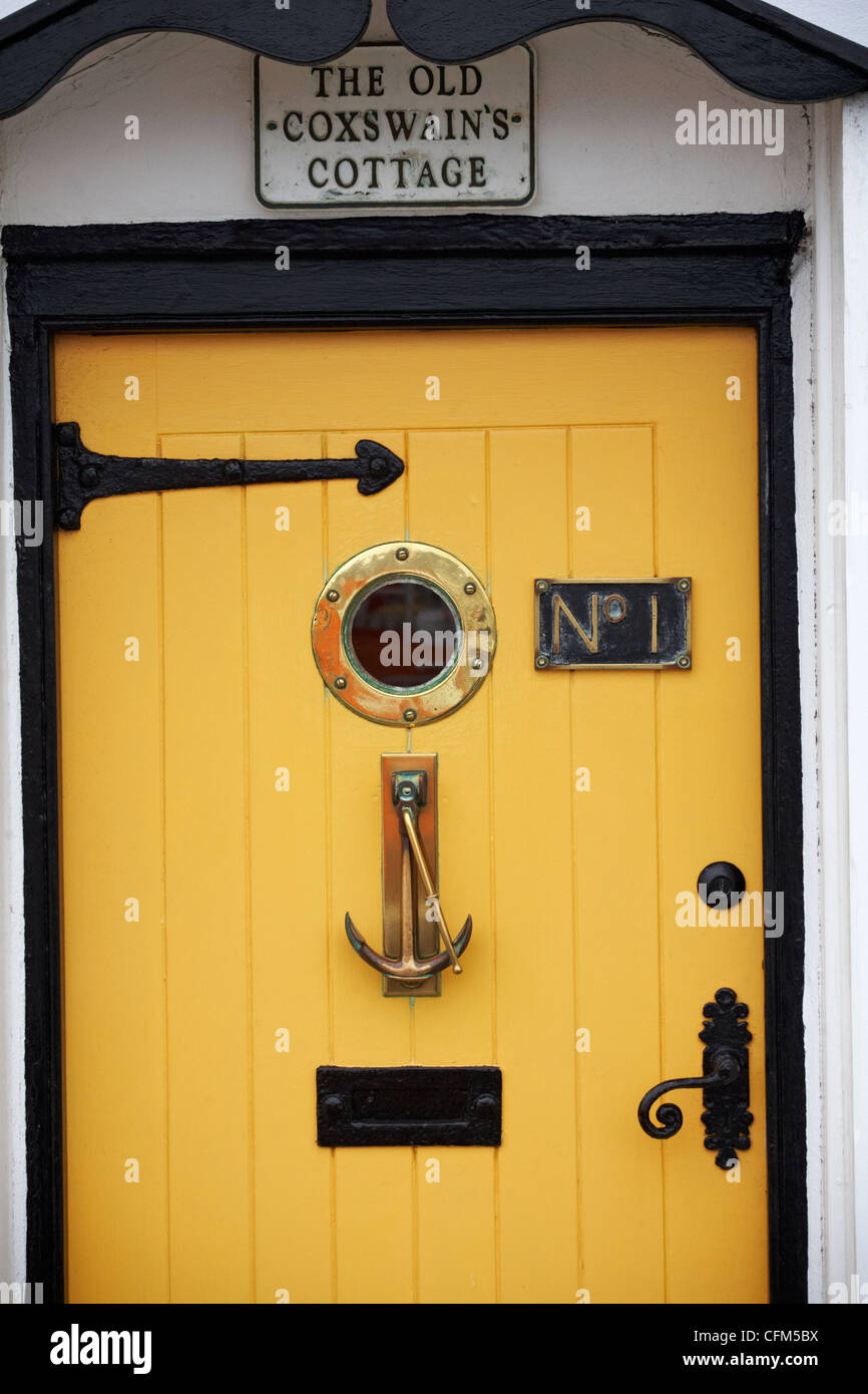 bright yellow front entrance door of The Old Coxswain's cottage No 1 at Weymouth in March Stock Photo