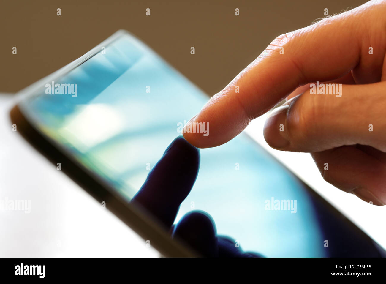 Finger touching screen of a digital tablet Stock Photo