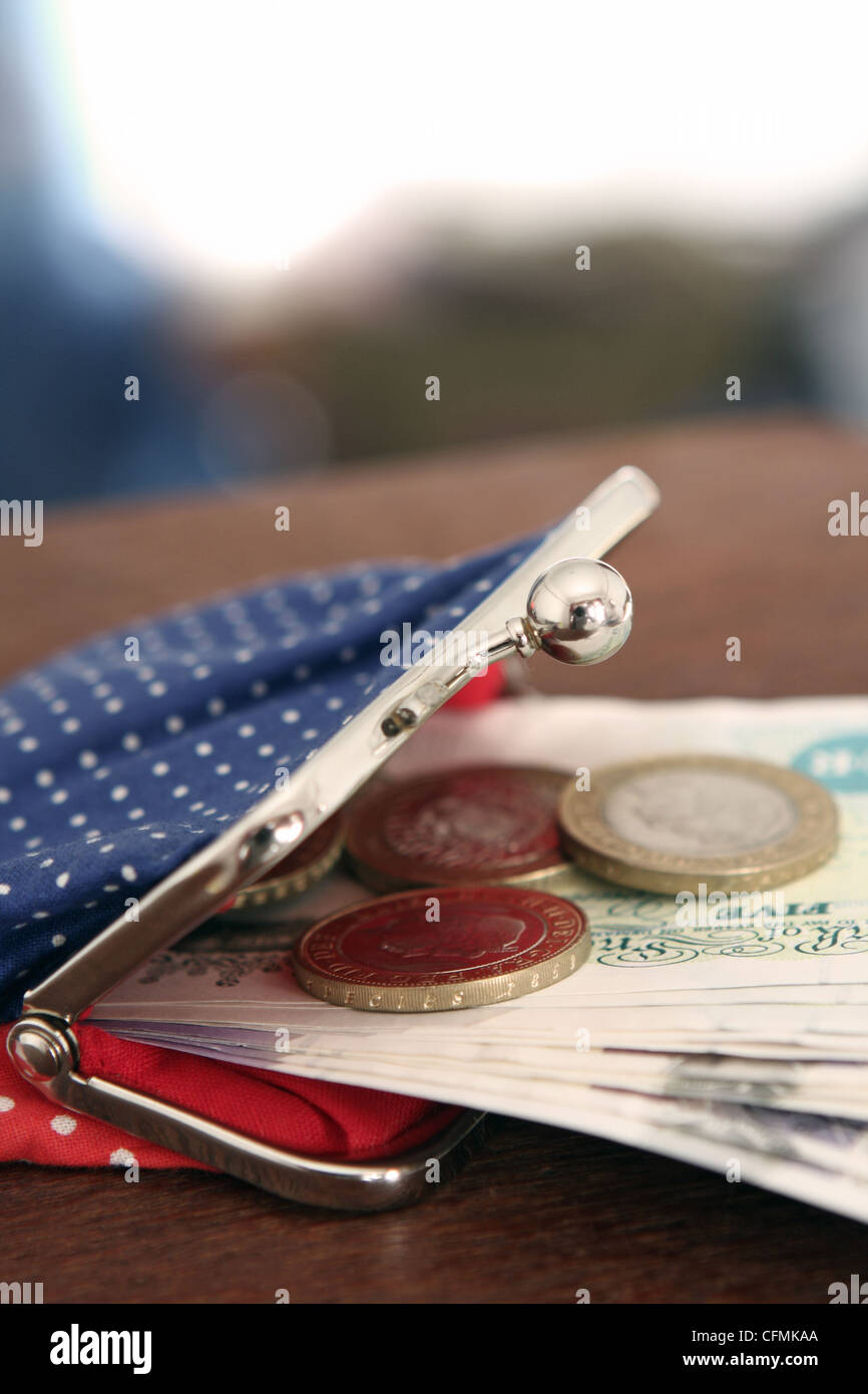 Sterling notes and coins sticking out of a lady's purse Stock Photo - Alamy