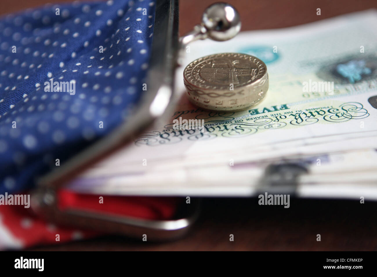 Sterling notes and coins sticking out of a lady's purse Stock Photo - Alamy