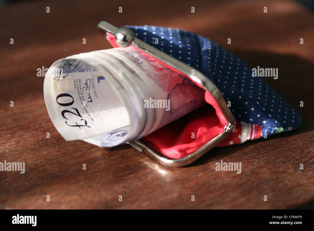 a bundle of rolled up £20 notes sticking out of a lady's purse Stock ...