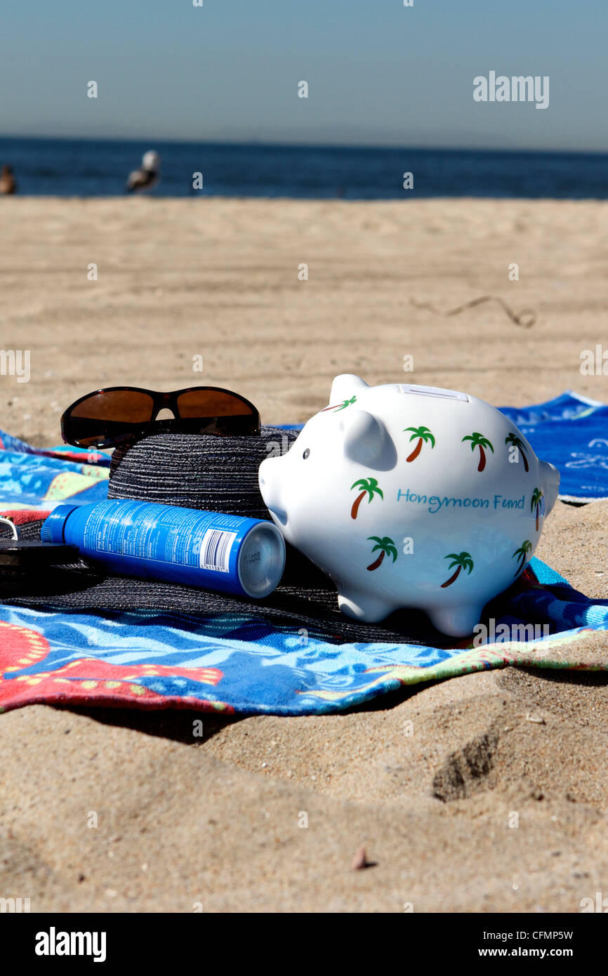 Honeymoon piggy bank savings on a beach Stock Photo