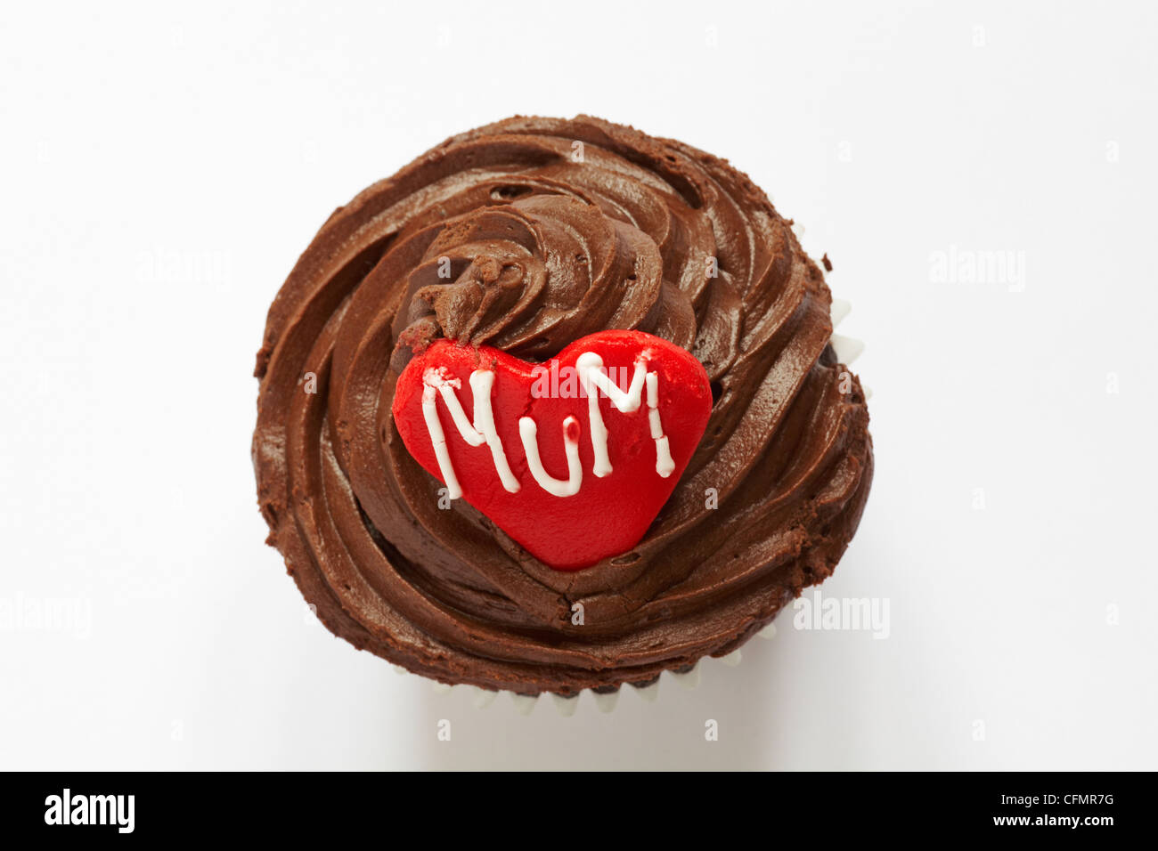 looking down on chocolate cupcake with the word mum iced on red heart for Mothering Sunday, Mothers Day isolated on white background - from above Stock Photo