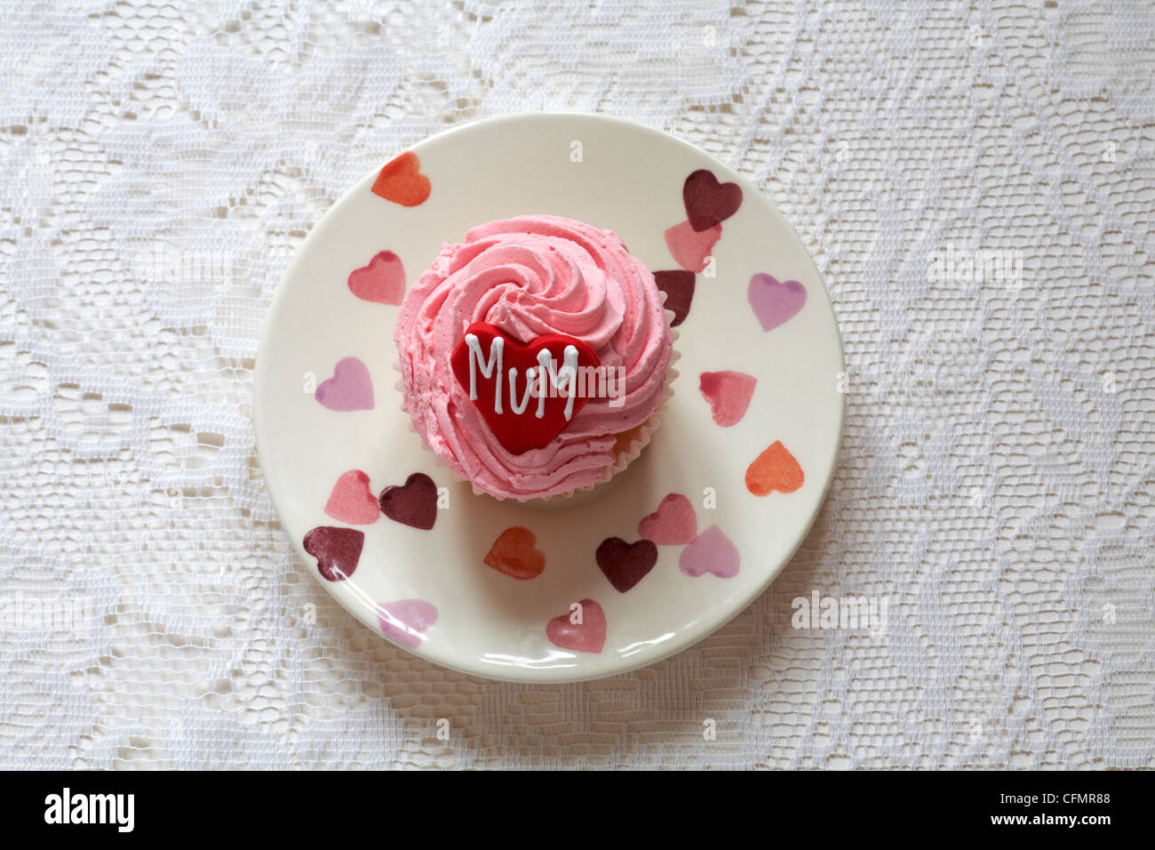 strawberry cupcake with the word mum iced on red heart for Mothering Sunday, Mothers Day set on plate with hearts on Stock Photo
