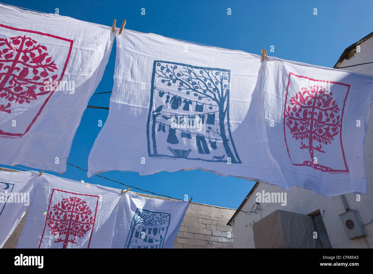 Handmade dish towels with silkscreen images drying outside. Stock Photo