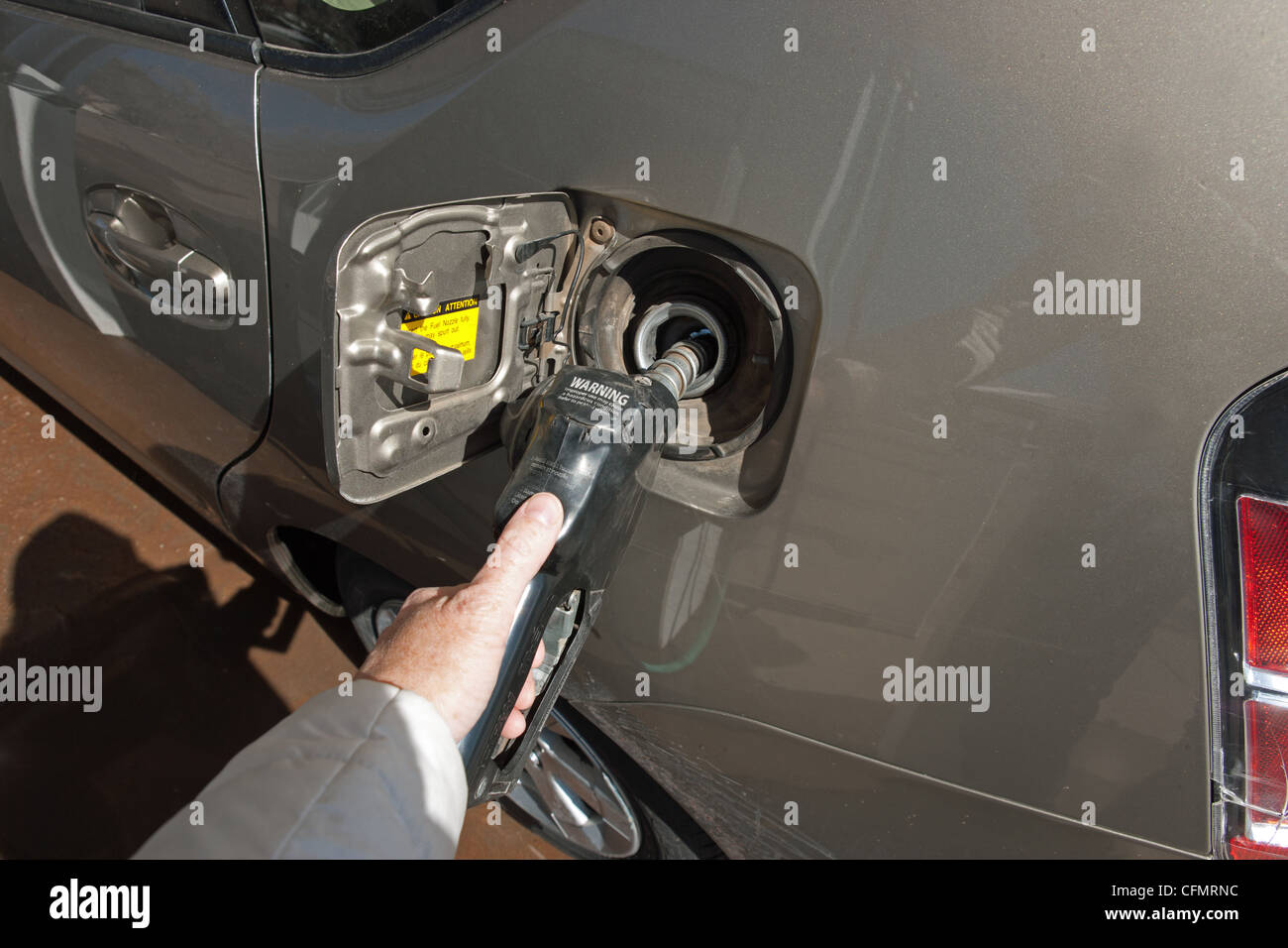 close up of hand pumping gas into a Toyota Prius. Stock Photo
