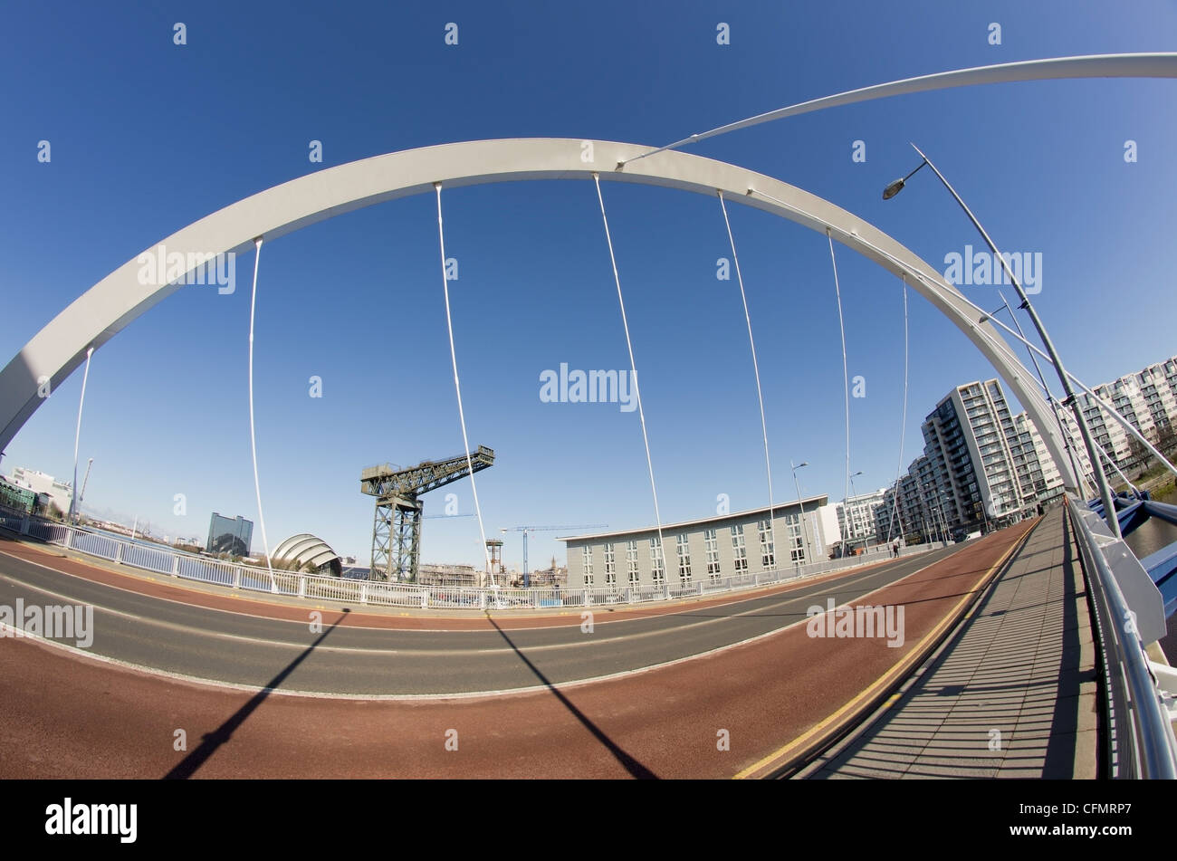 Sunshine and blue sky in Glasgow. Fisheye lens used to show span of Clyde Arc Bridge and riverfront landmarks in the background. Stock Photo