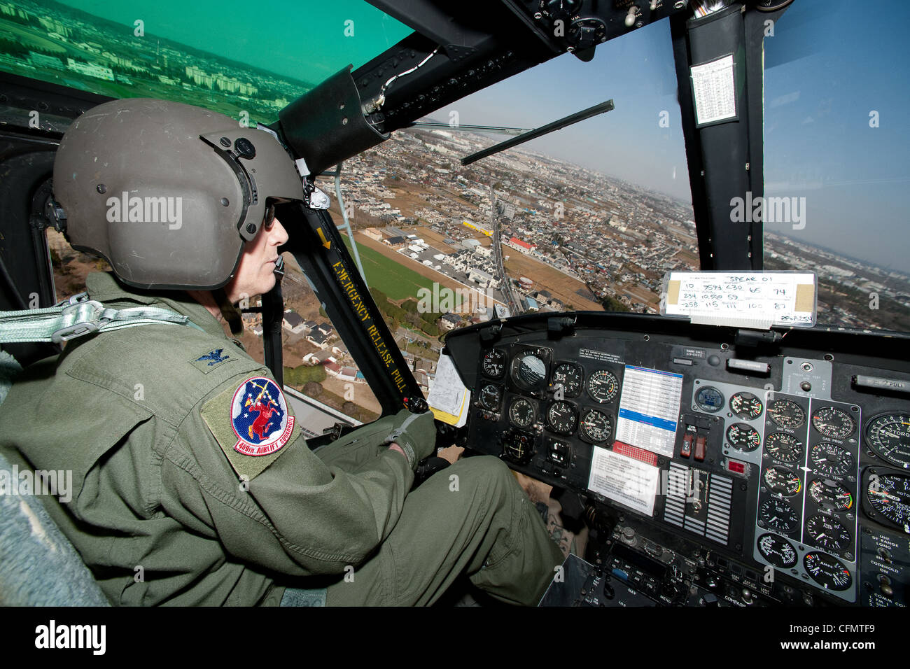 YOKOTA AIR BASE, Japan -- Col. Otto Feather, 374th Airlift Wing commander, flies over Yokota Air Base, Japan in a UH-1 Huey during his final flight, March 15, 2012. Known as the 'fini flight,' military aviators have a tradition where after completion of their final flight, aircrew members are met and hosed down with water by their squadron comrades, family and friends. Stock Photo