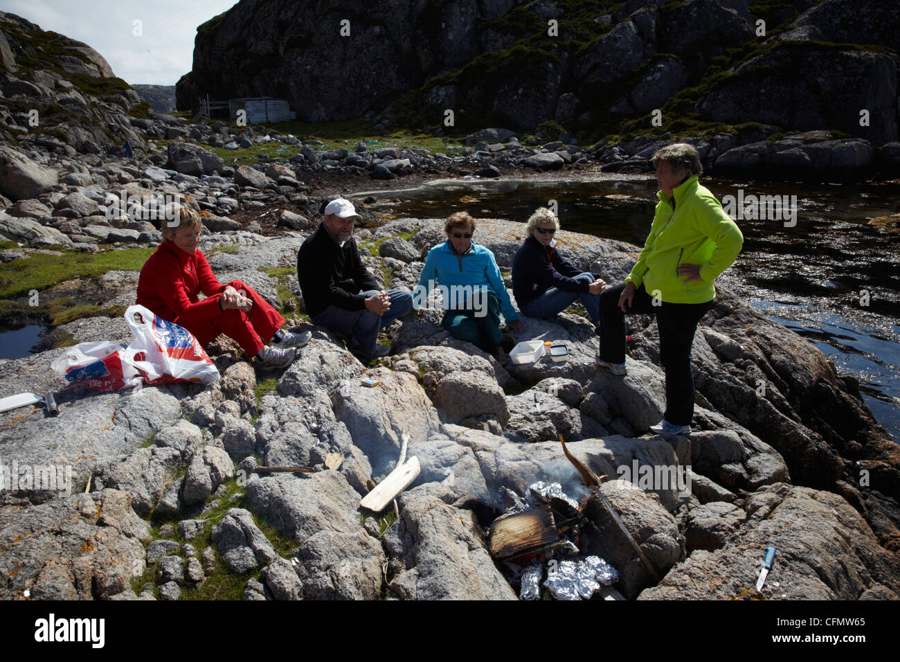 A group of five have lunch in the open air while visiting a small Island in Norway. Stock Photo