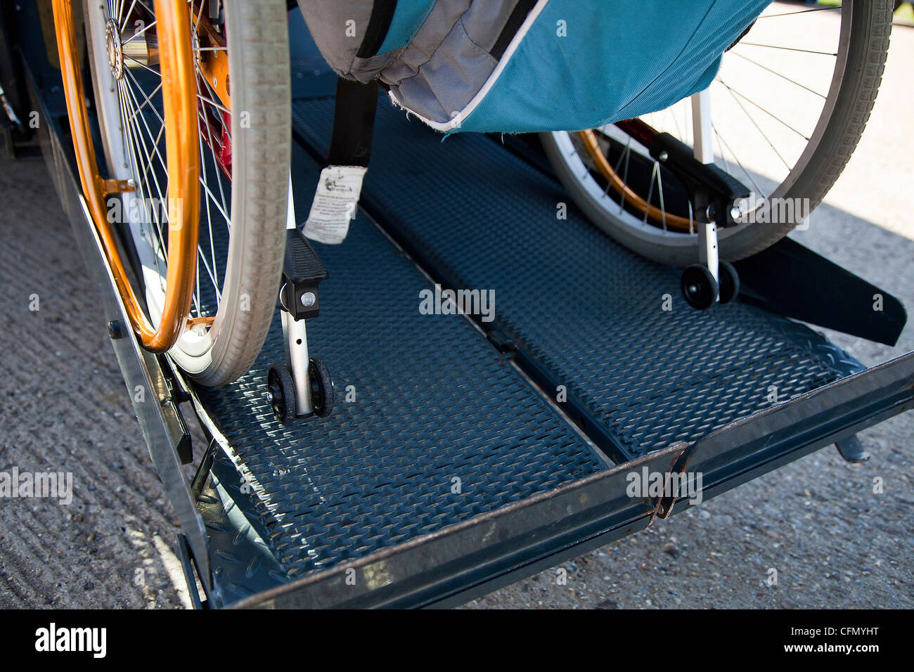 Wheelchair being raised up on tail lift of bus Stock Photo