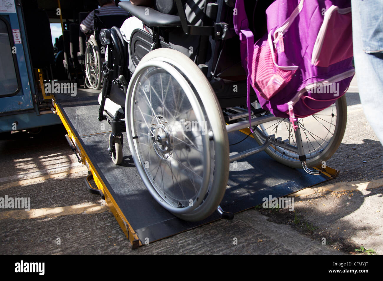 Wheelchair being pushed up ramp on to bus Stock Photo