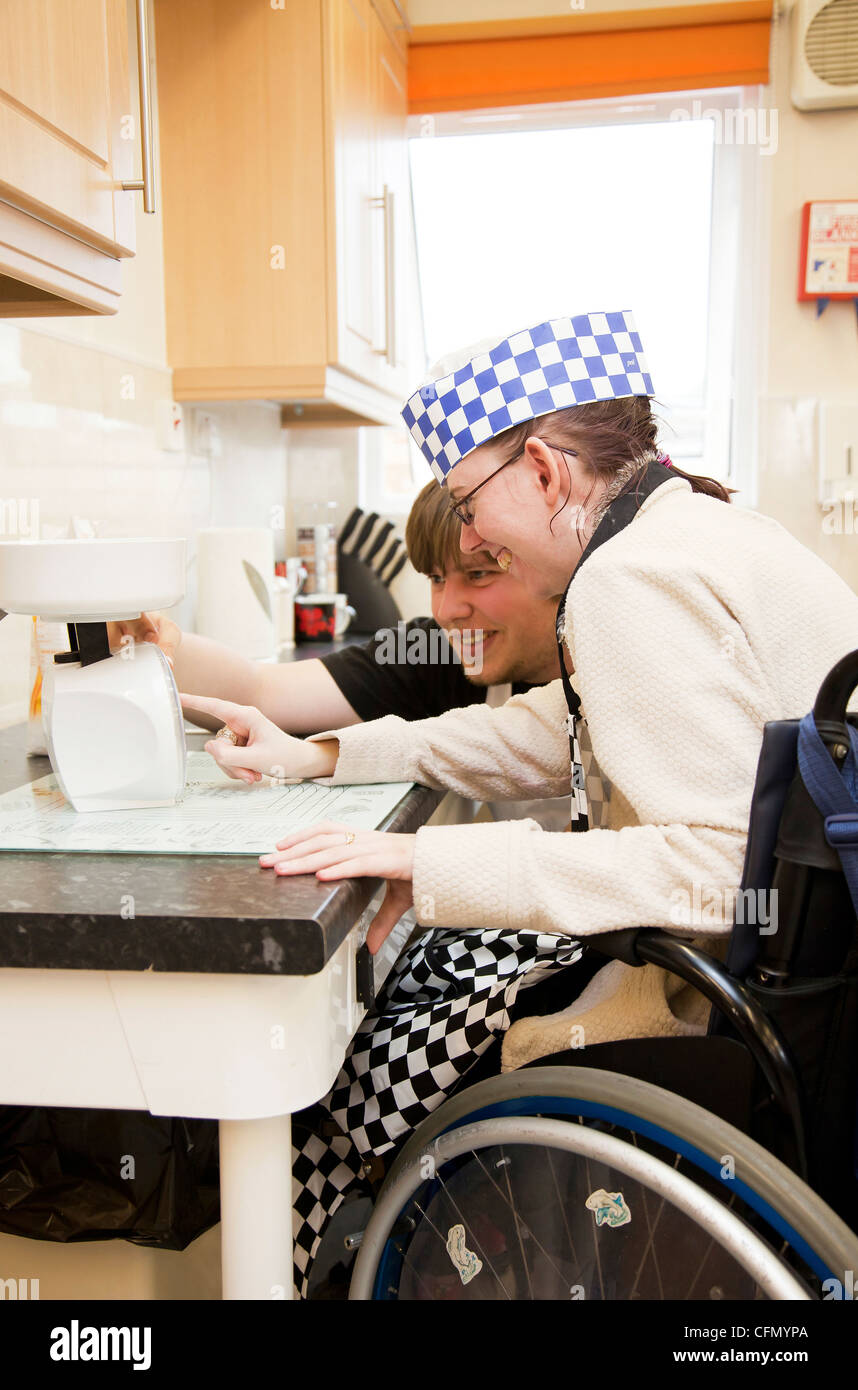 Disabled woman tries out adjustable worktop in charity's new kitchen Stock Photo
