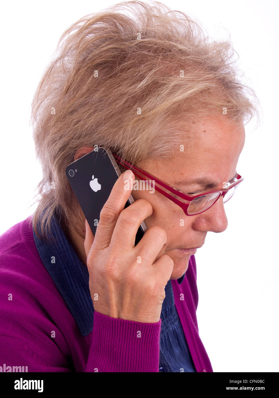 Close up of mature woman with red glasses talking on iPhone Stock Photo