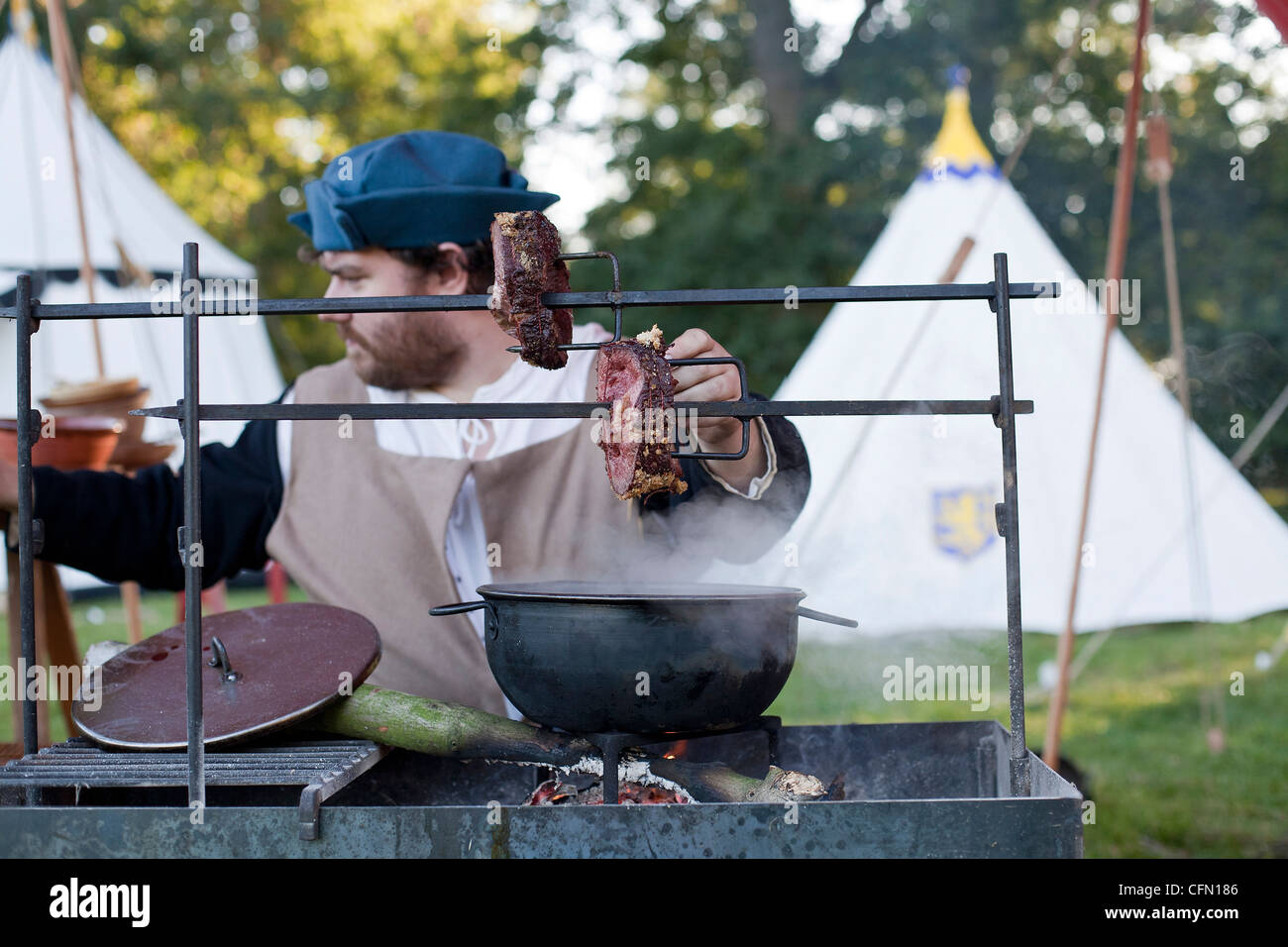 Spit roasting beef outdoors at living history encampment Stock Photo