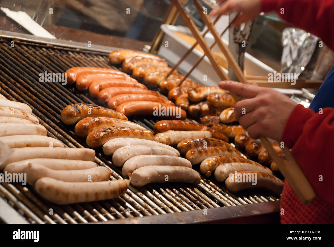 Bratwurst (German Sausage) cooking on a grill in a Christmas Market Stock Photo
