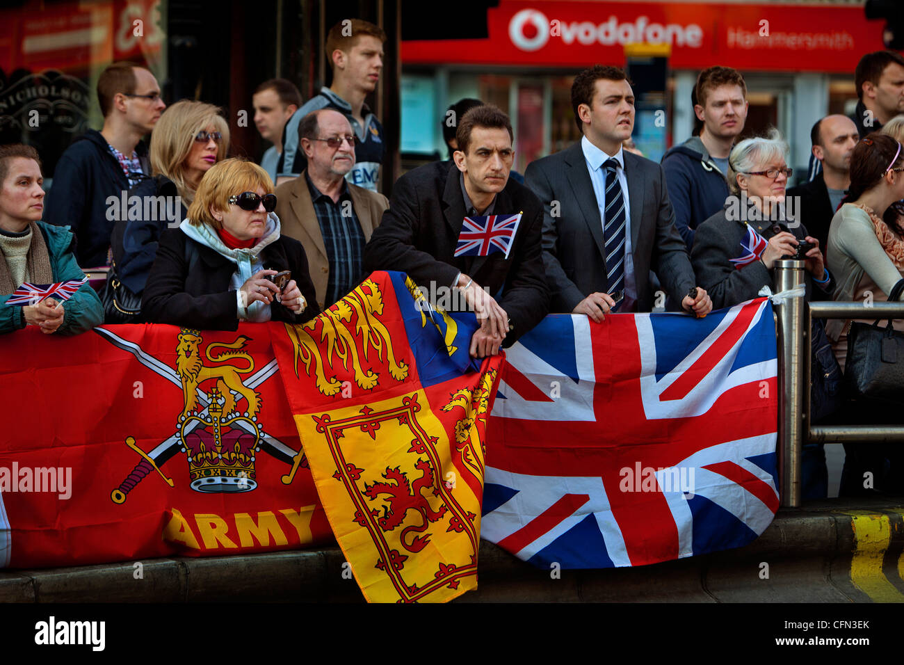 Spectators with patriotic flags watching a parade of the Royal Yeomanry through Hammersmith Stock Photo