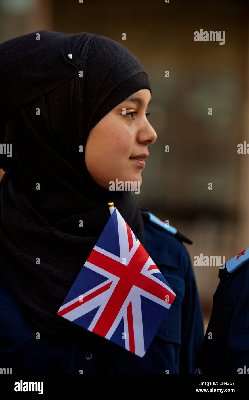 Volunteer Police Cadet with Union jack flag watching an army parade Stock Photo