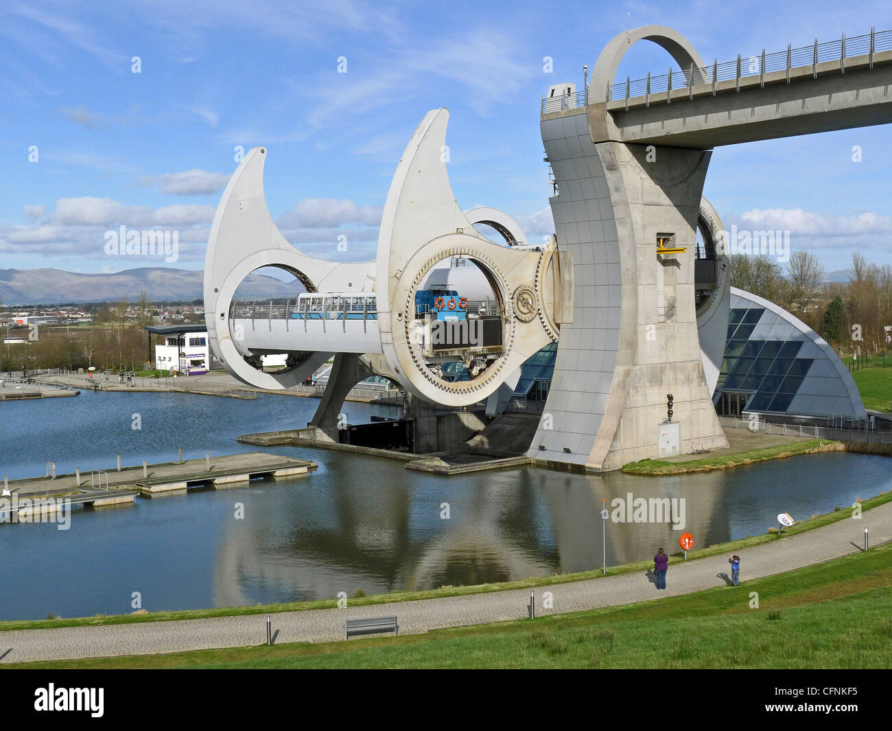 A view from the south/west of the Falkirk Wheel visitor attraction on a still and sunny early spring day with wheel turning Stock Photo