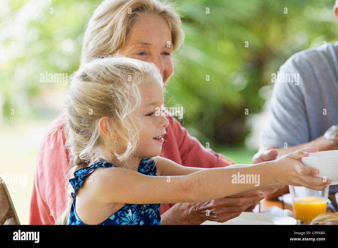 Girl having meal with family outdoors Stock Photo
