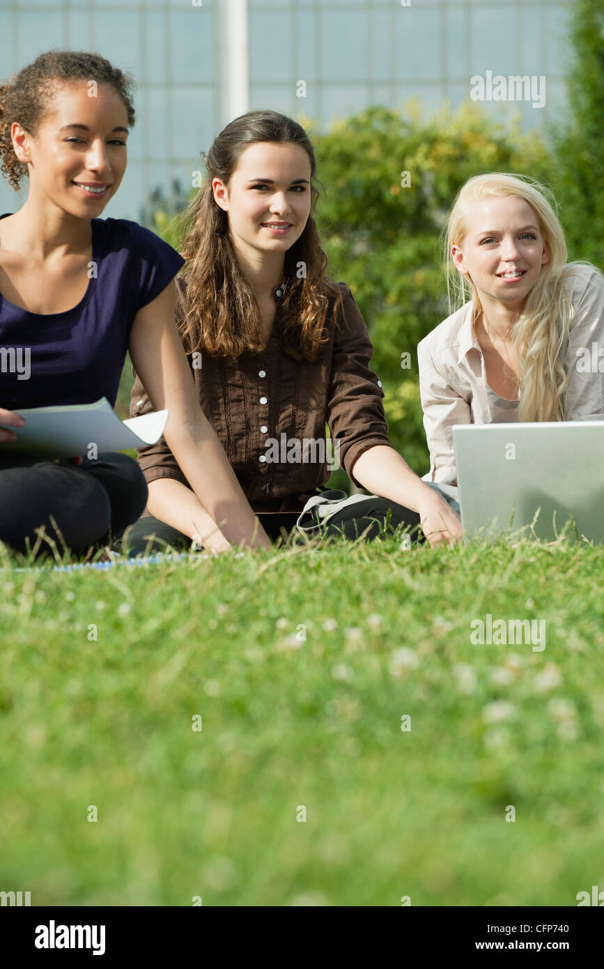 Female university students studying together on grass, low angle view Stock Photo