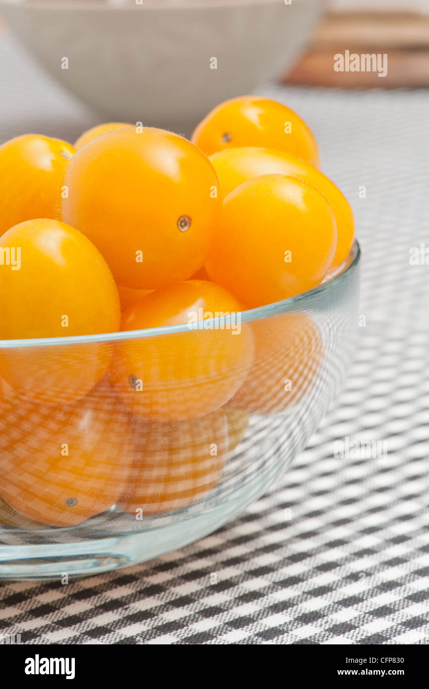 Glass bowl filled with yellow plum tomatoes Stock Photo