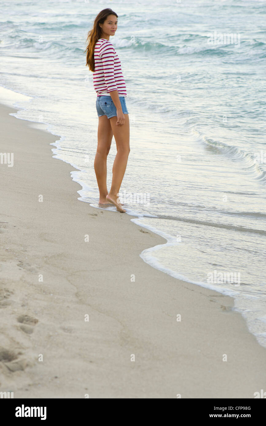 Young woman standing on beach Stock Photo - Alamy