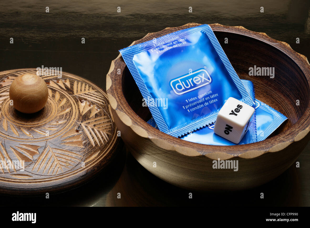 Condoms in wooden bowl with yes/no die Stock Photo