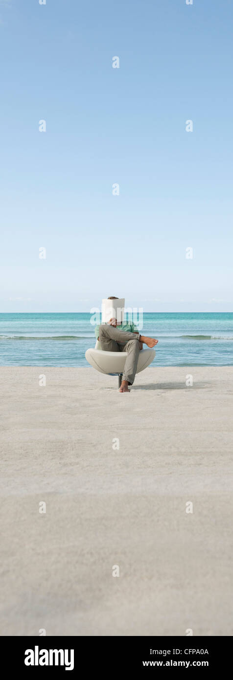 Man reading book at the beach Stock Photo