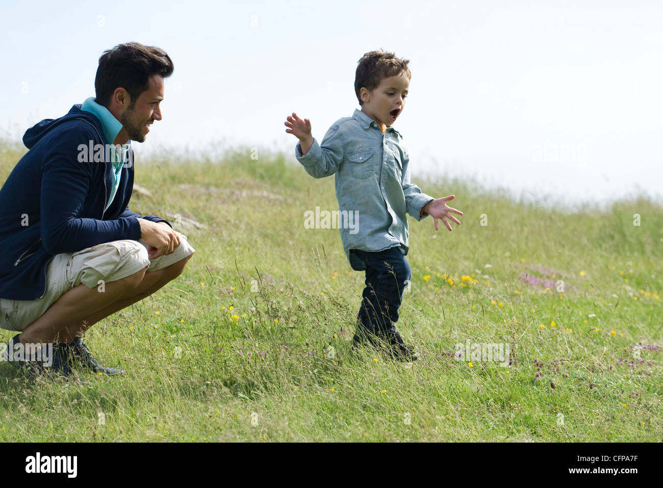 Father and son playing in meadow Stock Photo